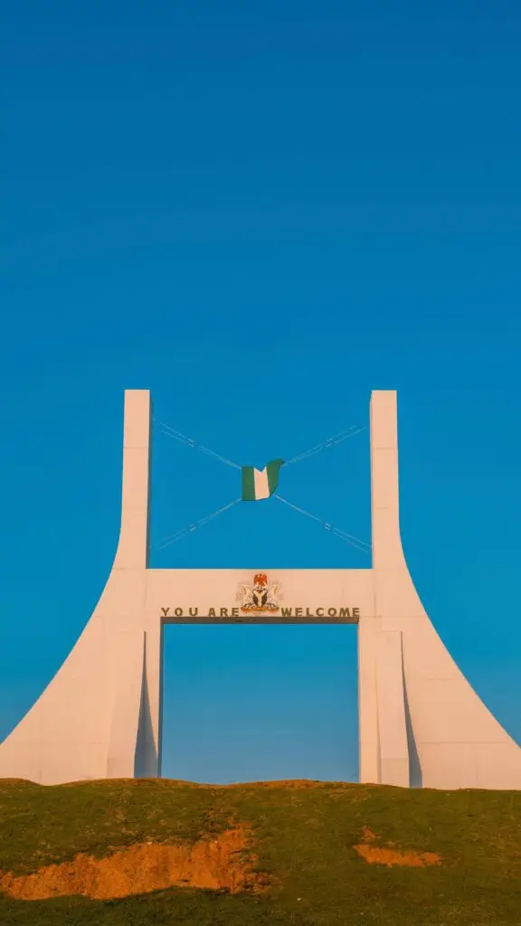 Captivating view of the Abuja City Gate with a clear blue sky, symbolizing Nigeria's capital.